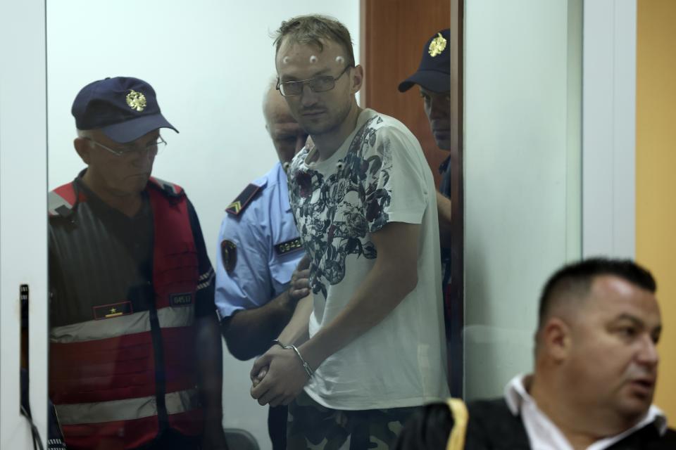 Ukrainian Fedir Alpatov guarded by police, arrives at a court in Elbasan, Albania, Wednesday, Aug. 24, 2022. Two Russians and a Ukrainian were arrested for alleged espionage at a military plant in southern Albania, on Saturday, Aug. 20. Two military guards were injured by a "neo-paralyzing spray" used by the Russian while resisting arrest according to the Albanian Defence Ministry. (AP Photo/Franc Zhurda)
