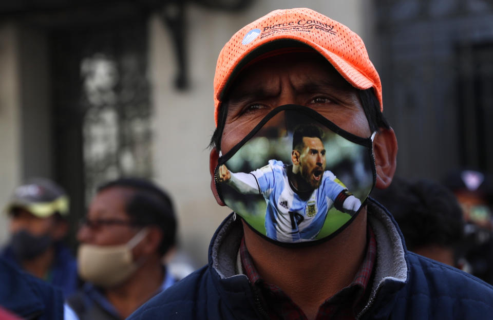 A public transport driver, wearing a protective face mask emblazoned with an image of Lionel Messi, attends a protest demanding an increase in fares because quarantine measures to curb the spread of the new coronavirus have decreased his income, in La Paz, Bolivia, Wednesday, July 1, 2020. (AP Photo/Juan Karita)