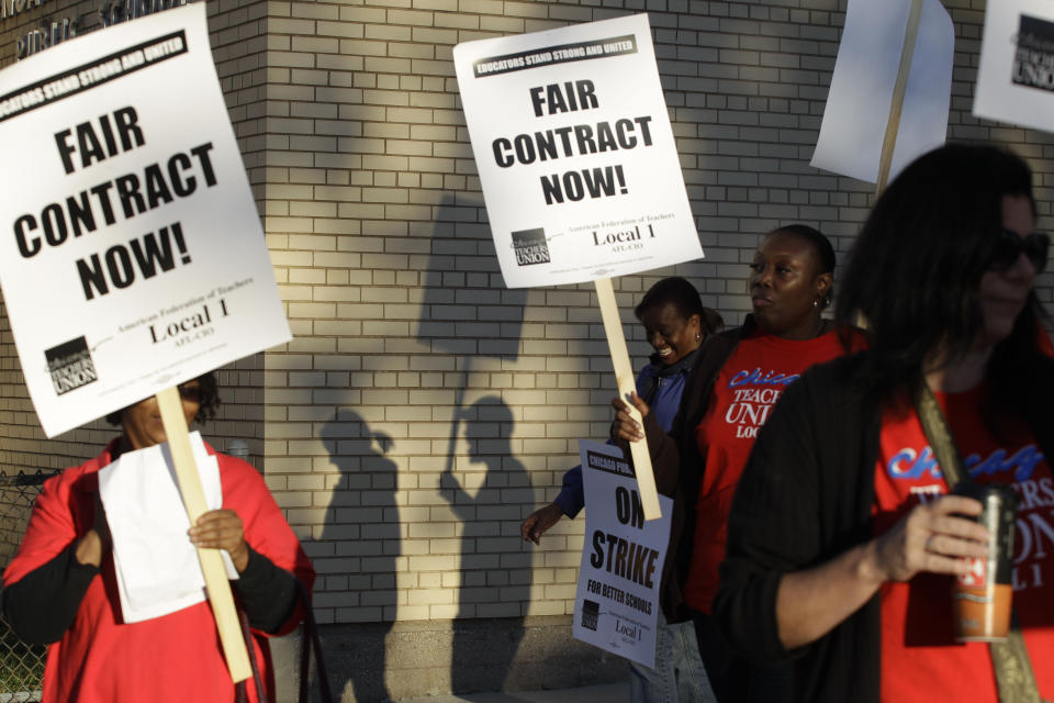 FILE - This Sept. 10, 2012 file photo shows Chicago teachers walk walking a picket line outside a school in Chicago, after they went on strike for the first time in 25 years. Teachers in Chicago, the nation's third-largest school district, again are inching closer to a strike that could take place as early as next month. AP Photo/M. Spencer Green, File)