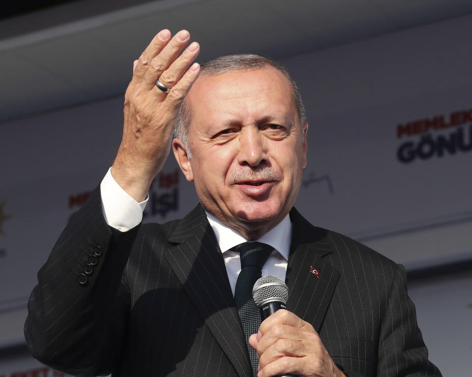 Turkey's President Recep Tayyip Erdogan salutes the supporters of his ruling Justice and Development Party during a rally in Kocaeli, Turkey, Tuesday, March 19, 2019. Ignoring widespread criticism, Erdogan on Tuesday again showed excerpts of a video taken by the attacker who killed 50 people in mosques in New Zealand, to denounce rising hatred and prejudice against Islam. (Presidential Press Service via AP, Pool)