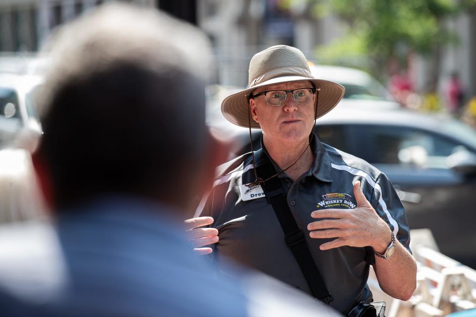 Drew Shryock talked about the history of bourbon while leading tour group down Main St. in Downtown, Louisville, Ky. Shryock is the creator and guide for the Whiskey Row Walking Tour. June 9, 2023