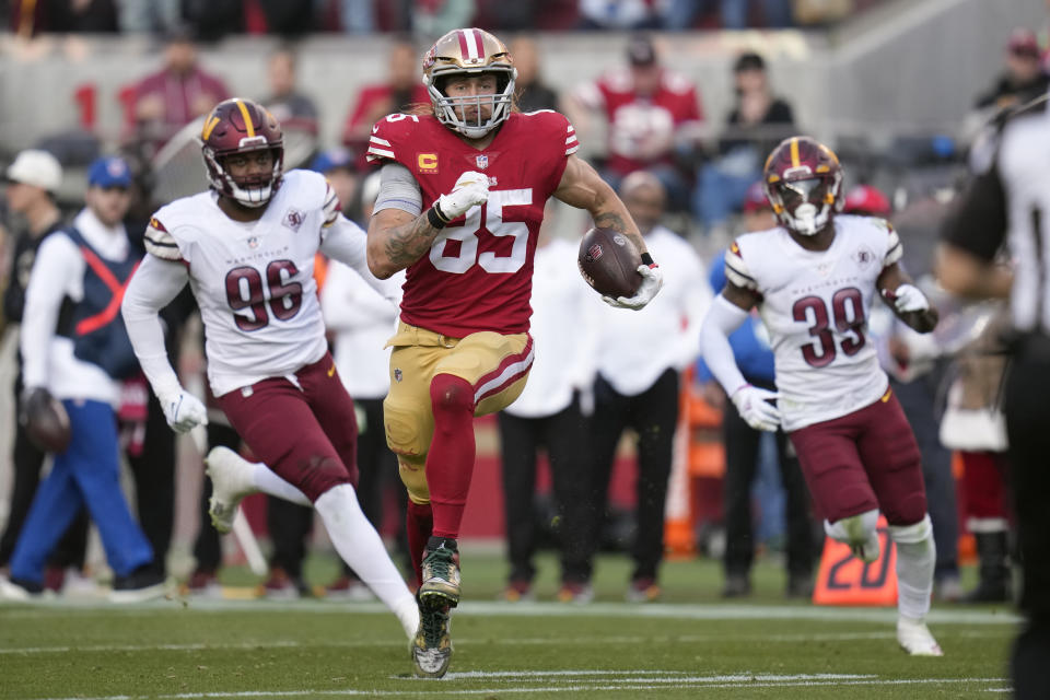 San Francisco 49ers tight end George Kittle (85) rushes the ball past Washington Commanders defensive end James Smith-Williams (96) and safety Jeremy Reaves (39) in the second half of an NFL football game, Saturday, Dec. 24, 2022, in Santa Clara, Calif. (AP Photo/Godofredo A. Vásquez)