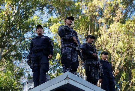 Police officers stand guard at the headquarters of Honduras' elite police force, after an agreement with the government not to crack down on demonstrators in the marches over a contested presidential election, according to local media, in Tegucigalpa, Honduras December 5, 2017. REUTERS/Henry Romero