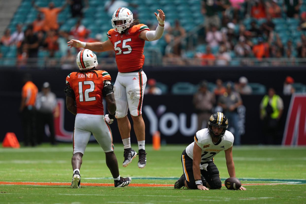 Miami Hurricanes defensive lineman Jacob Lichtenstein (55) celebrates with defensive lineman Jahfari Harvey (12) after sacking Southern Miss Golden Eagles quarterback Zach Wilcke (12) during the first half at Hard Rock Stadium in Miami Gardens.