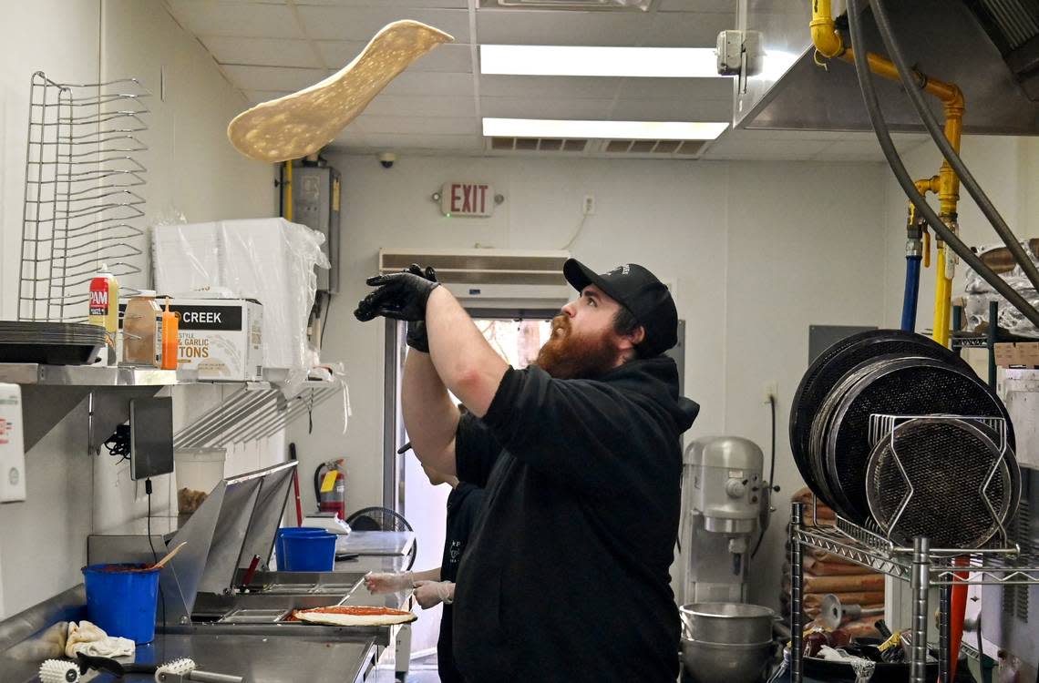 Josh Walsh, co-owner of Cow Pies Pizza Co. at 6001 Watson Blvd. in Byron tosses pizza dough.