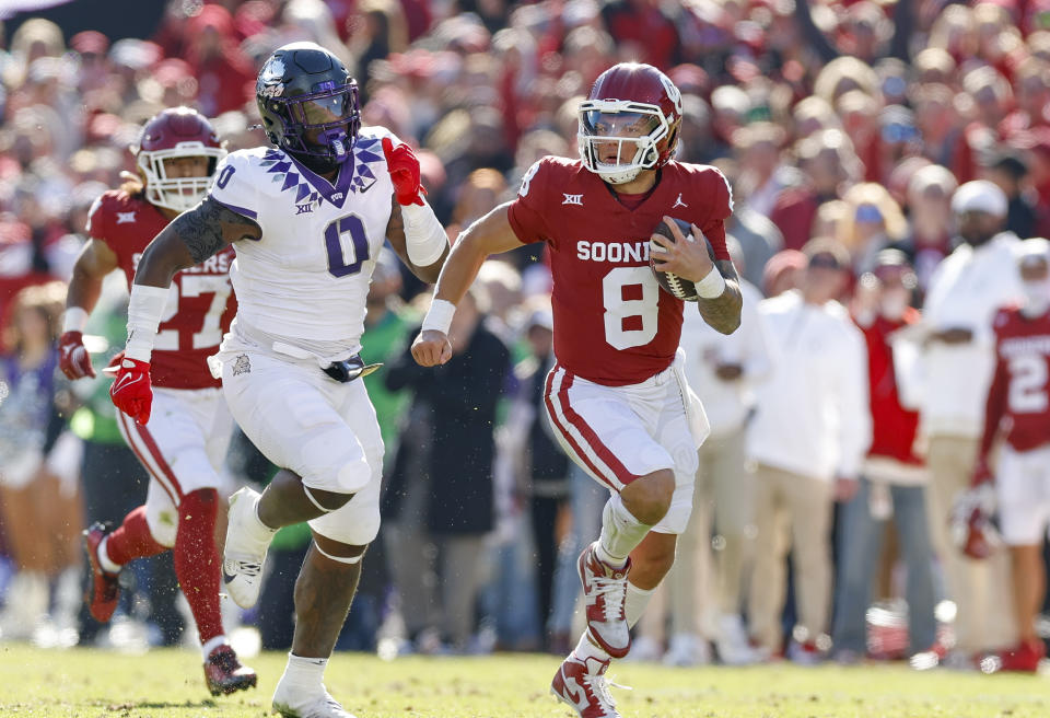 Oklahoma quarterback Dillon Gabriel (8) runs for a a first down ahead of TCU linebacker Shad Banks Jr. (0) during the second half of an NCAA college football game Friday, Nov. 24, 2023, in Norman, Okla. Oklahoma won 69-45. (AP Photo/Alonzo Adams)