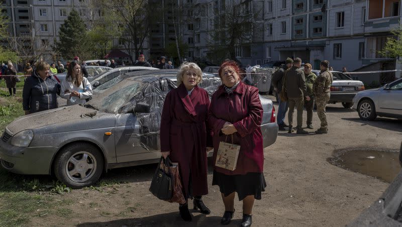 Residents watch the destruction of a residential building that was hit during a Russian attack in Uman, central Ukraine, Friday, April 28, 2023.
