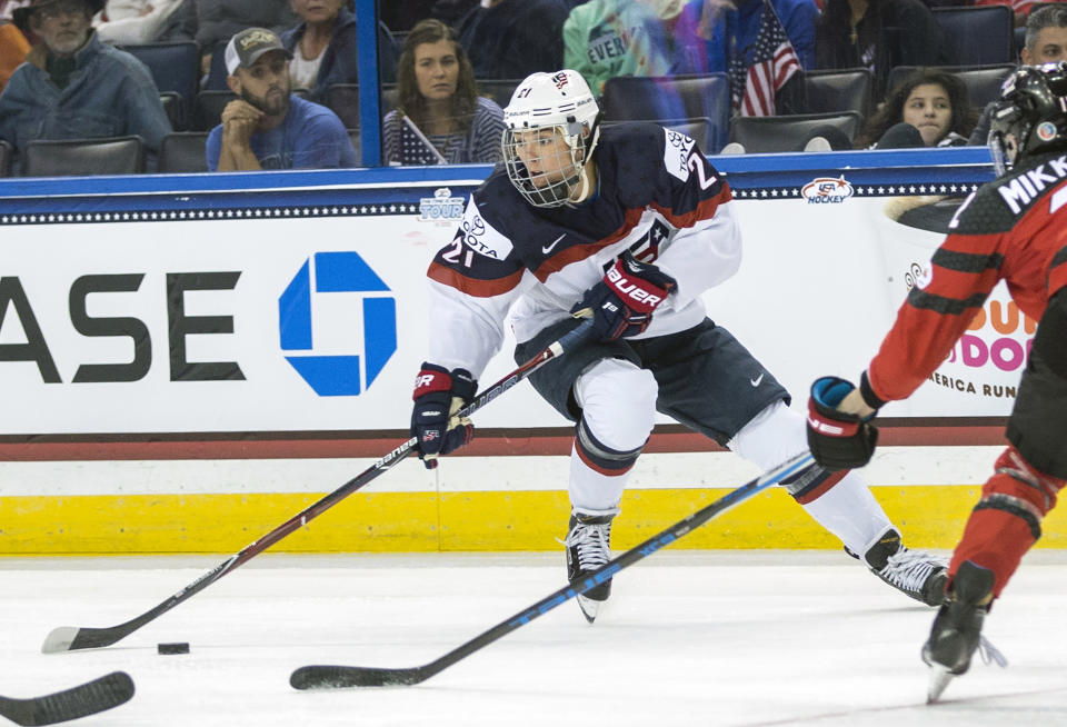 FILE - In this Nov. 12, 2017, file photo, United States' Hilary Knight (21) controls the puck in front of Canada's Meaghan Mikkelson, right, during the second period of the Four Nations Cup championship hockey game in Tampa, Fla. Knight has a gold medal. What she would like is a full-time job. Not just for her. For the other 200-plus members of the Professional Women’s Hockey Players’ Association too. One that pays all of them well enough to simply go play instead of forcing most to find side gigs just to get by. One that provides adequate medical insurance. One that provides something resembling stability. (AP Photo/Willie J. Allen Jr., File)