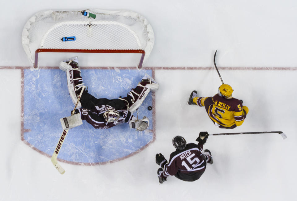 Union's Colin Stevens, left, makes the pad-save on a shot by Minnesota's Mike Reilly, right, during the second period of an NCAA men's college hockey Frozen Four tournament game on Saturday, April 12, 2014, in Philadelphia. (AP Photo/Chris Szagola)