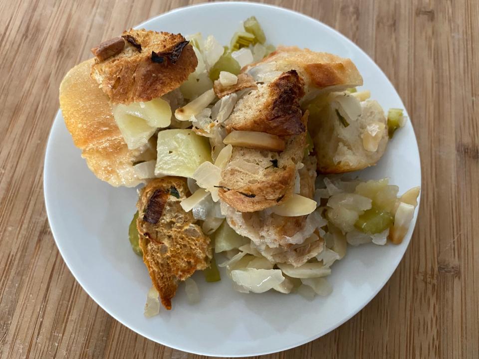 Ina Garten's stuffing serving on a white plate on a wooden cutting board