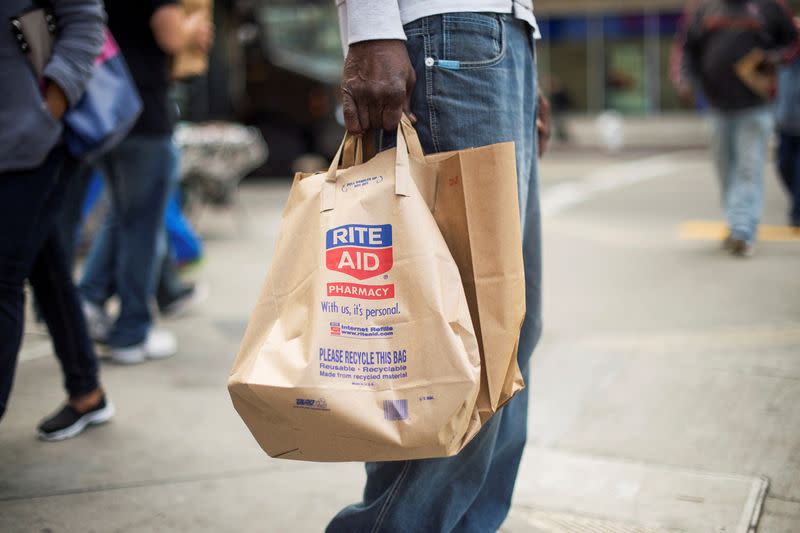 FILE PHOTO: A shopper carries bags out of a Rite Aid store in Oakland California