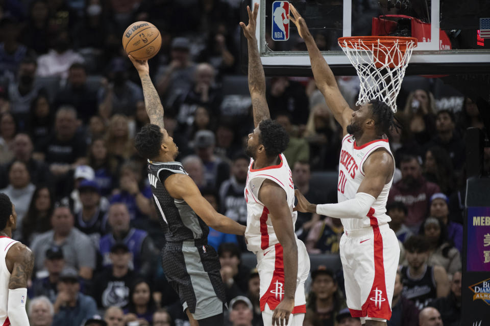 Houston Rockets forward Tari Eason, center, and forward Bruno Fernando (20) defend against Sacramento Kings guard Malik Monk during the first half of an NBA basketball game in Sacramento, Calif., Wednesday, Jan. 11, 2023. (AP Photo/José Luis Villegas)