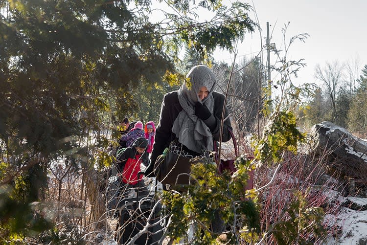 A migrant mother from Yemen leads her family across the Canadian border at Roxham Road in  Quebec on March 5, 2017.