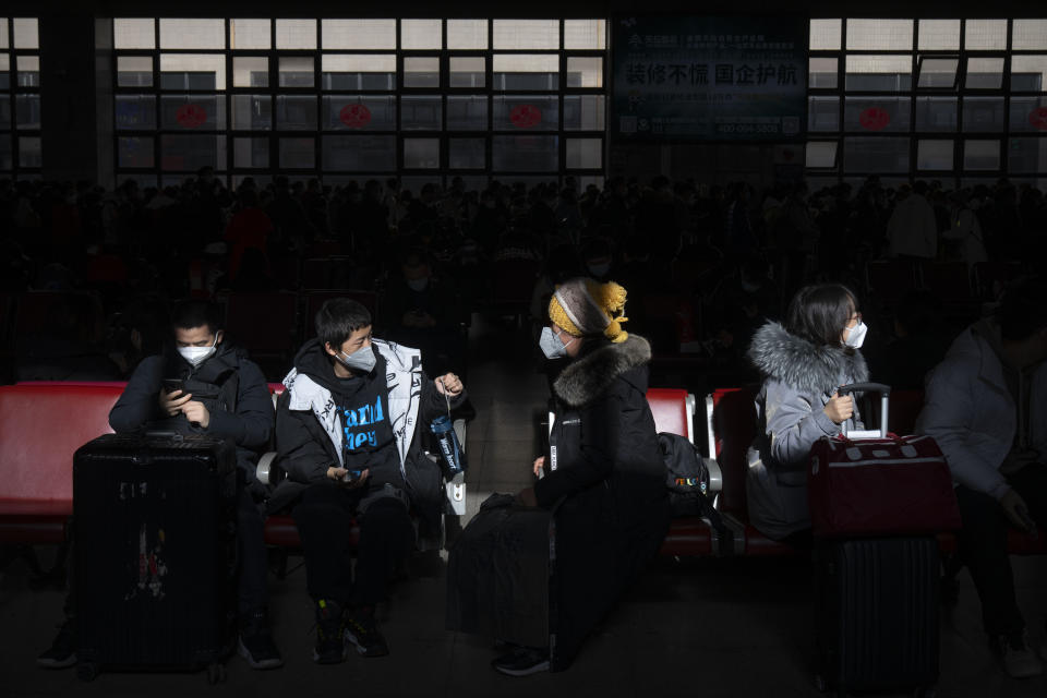 Travelers sit in a waiting room at Beijing West Railway Station in Beijing, Wednesday, Jan. 18, 2023. China in December lifted its strict "zero-COVID" policy, letting loose a wave of pent-up travel desire, particularly around China's most important time for family gatherings, referred to in China as the Spring Festival, that may be the only time in the year when urban workers return to their hometowns. (AP Photo/Mark Schiefelbein)