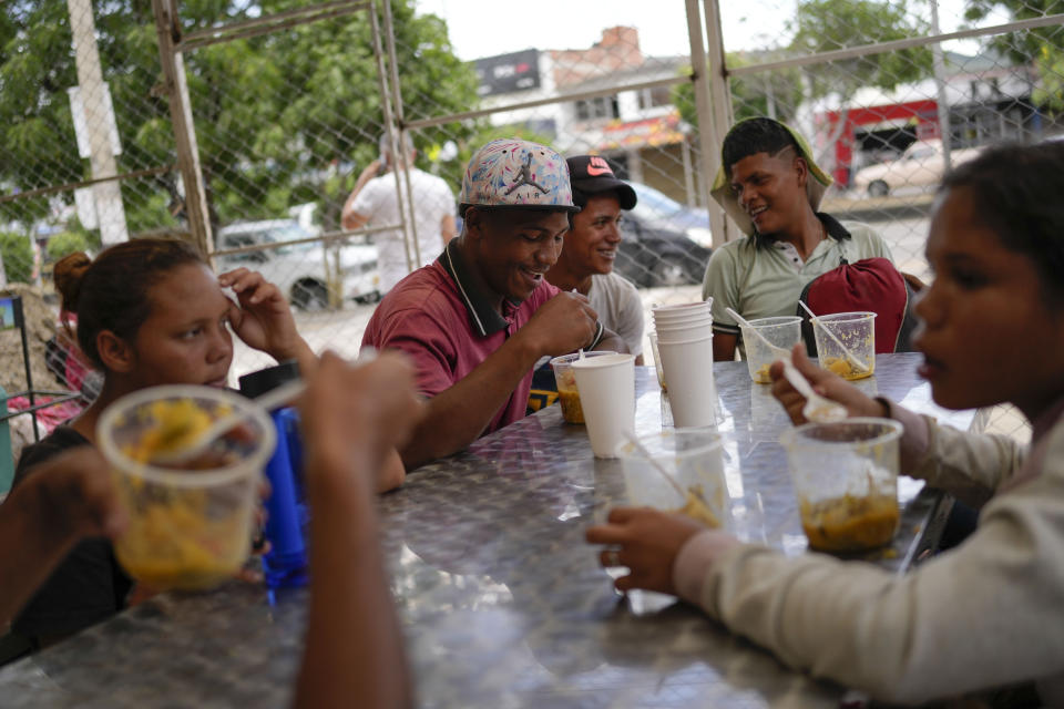 FILE - Venezuelan Frank Fernandez, center, eats with friends at the Colombian-Venezuelan Foundation "Nueva Ilusión" soup kitchen near the border with Venezuela in Los Patios, Colombia, Aug. 6, 2022. “Hope is the last thing to be lost, but at the moment, there is none,” Fernandez said as he tried to contact his family to let them know he had reached Colombia with his brother after walking up to 25 miles (40 kilometers) a day. (AP Photo/Matias Delacroix, File)