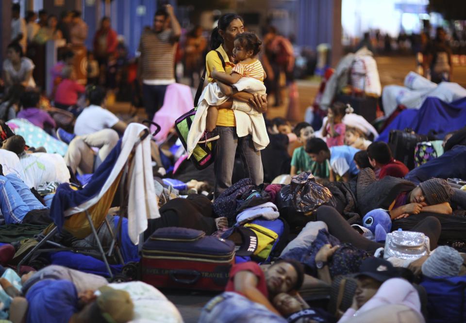 A Venezuelan migrants migrants wait to pass migration controls before the deadline on new regulations, in Tumbes, Peru, Friday, June 14, 2019. Venezuelan citizens are rushing to enter Peru before the implementation of new entry requirements on migrants fleeing the crisis-wracked South American nation. (AP Photo/Martin Mejia)