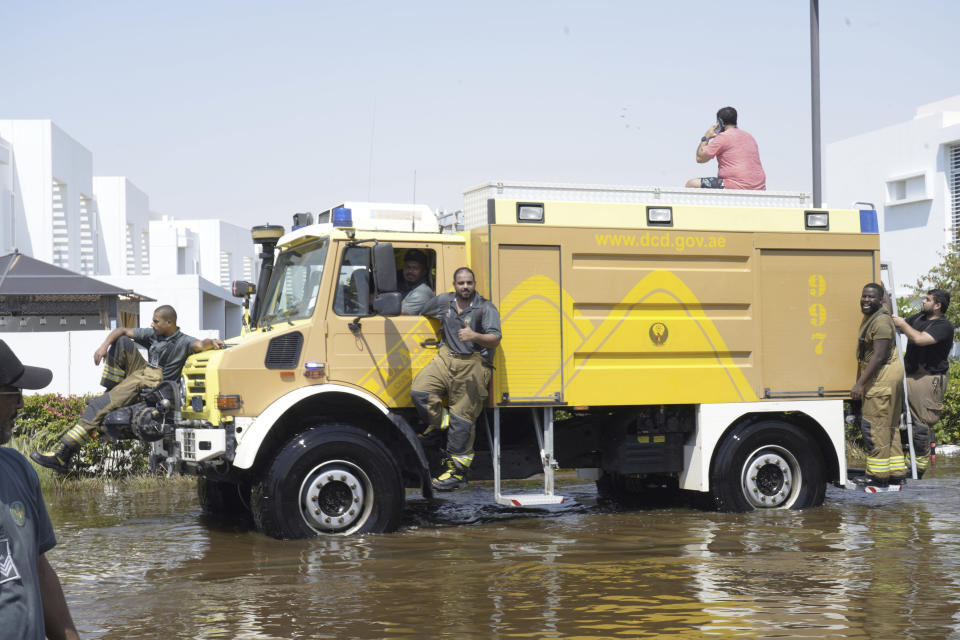 Dubai civil defense officials drive through floodwater in the Mudon neighborhood in Dubai, United Arab Emirates, Thursday, April 18, 2024. The United Arab Emirates attempted to dry out Thursday from the heaviest rain the desert nation has ever recorded — a deluge that flooded out Dubai International Airport and disrupted flights through the world's busiest airfield for international travel. (AP Photo/Jon Gambrell)