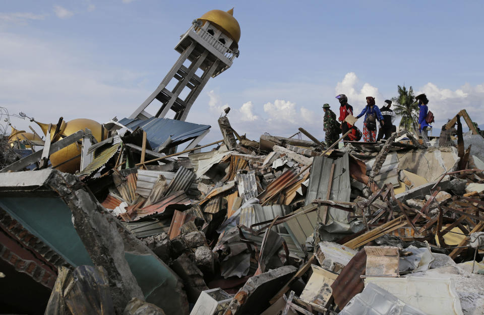 In this Oct. 6, 2018, photo, villagers wait for any word on their missing relatives lost in the Balarola neighborhood of Palu city when a massive earthquake caused the soil to loosen like a liquid, swallowing some homes whole and collapsing others into piles of rubble in Central Sulawesi, Indonesia. The 7.5 magnitude quake triggered not just a tsunami that leveled huge swathes of the region's coast, but a geological phenomenon known as liquefaction, making the soil move like liquid and swallowing entire neighborhoods. (AP Photo/Aaron Favila, File)