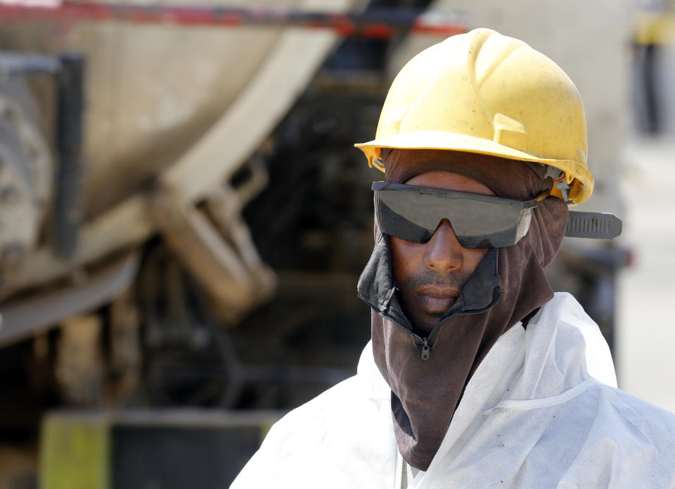 In this photo opportunity during a trip organized by Saudi information ministry, a worker wears safety gear in the Aramco's Khurais oil field, Saudi Arabia, Friday, Sept. 20, 2019, after it was hit during Sept. 14 attack. Saudi officials brought journalists Friday to see the damage done in an attack the U.S. alleges Iran carried out. (AP Photo/Amr Nabil)