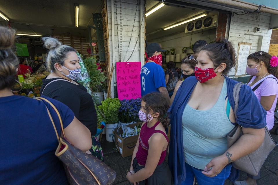 <span class="caption">California has allowed some retail businesses to reopen, including car dealerships, clothing stores and bookstores. Here, people appear to pass close in the flower district of Los Angeles.</span> <span class="attribution"><a class="link " href="https://www.gettyimages.com/detail/news-photo/people-pass-close-to-one-another-as-businesses-in-the-news-photo/1212203517?adppopup=true" rel="nofollow noopener" target="_blank" data-ylk="slk:Getty Images / David McNew;elm:context_link;itc:0;sec:content-canvas">Getty Images / David McNew</a></span>