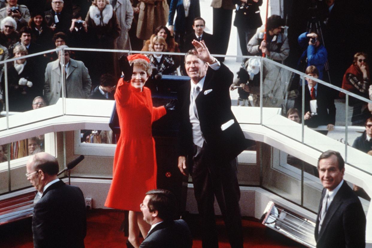 Nancy Reagan, known for her preference for the color red, joins husband Ronald Reagan in waving to supporters during his 1981 inauguration.