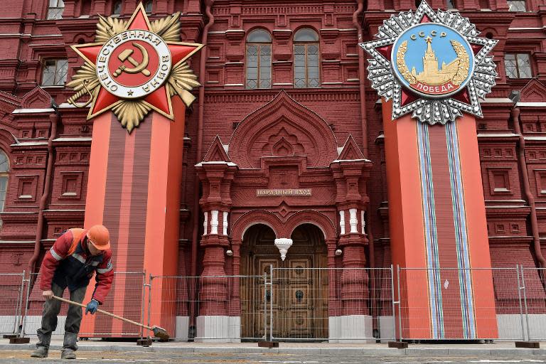 Russian municpal workers scatter sand in front of State Historical museum decorated for the upcoming Victory Day celebrations on Red Square, Moscow, on April 30, 2015