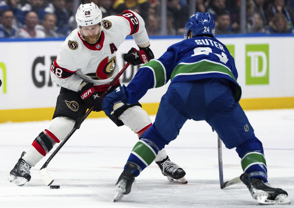 Ottawa Senators Claude Giroux (28) and Vancouver Canucks Pius Suter (24) vie for the puck during the second period of an NHL hockey game Tuesday, Jan. 2, 2024, in Vancouver, British Columbia. (Ethan Cairns/The Canadian Press via AP)