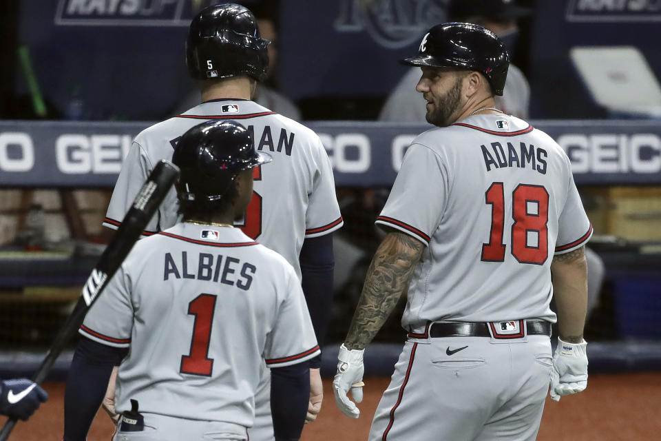 Atlanta Braves' Matt Adams (18) celebrates his three-run home run off Tampa Bay Rays relief pitcher Jalen Beeks with Freddie Freeman (5) and Ozzie Albies (1) during the sixth inning of a baseball game Monday, July 27, 2020, in St. Petersburg, Fla. (AP Photo/Chris O'Meara)