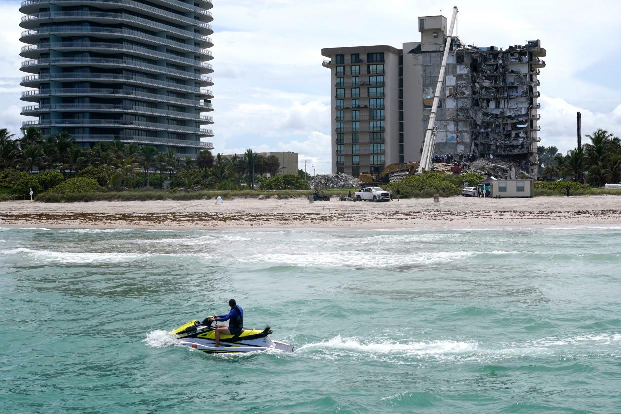 A jet ski rides by as rescue workers search in the rubble for survivors at the Champlain Towers South condominium, Saturday, June 26, 2021, in the Surfside area of Miami. The building partially collapsed on Thursday.