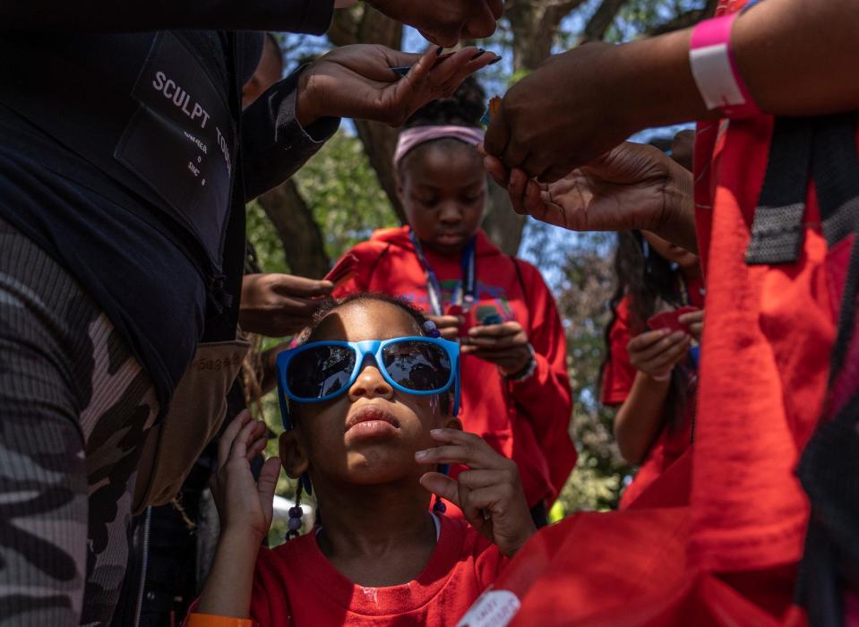 Toya Bohana, of Detroit, wears her sunglasses as family members check raffle tickets to see whether they have won items being given away during the Community Resource Fair at Christ the King Catholic School in Detroit on Aug. 18, 2023.