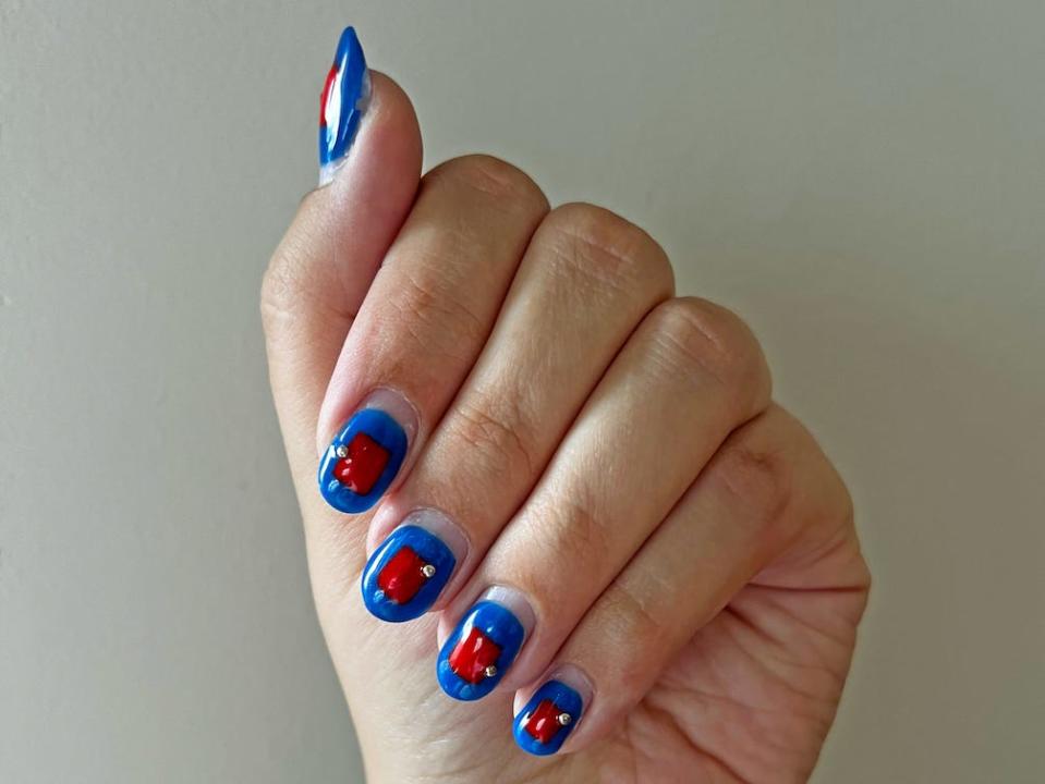hand displaying a red and blue manicure