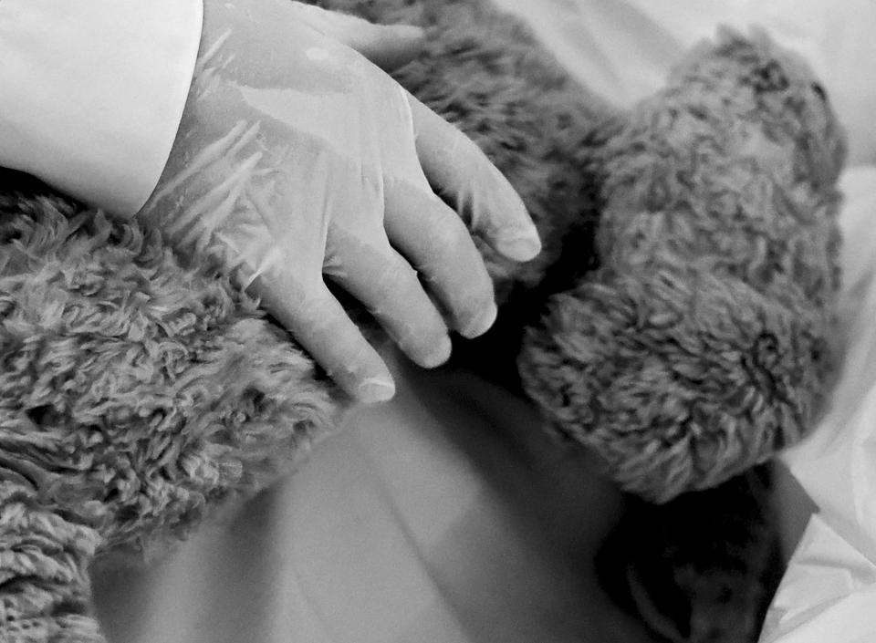 A Wiscombe Memorial employee tucks Bernard, Paul Youngblood’s beloved stuffed animal pillow, against his body after his death at The INN Between in Salt Lake City on Friday, Aug. 11, 2023. Youngblood requested that Bernard be buried with him. | Laura Seitz, Deseret News