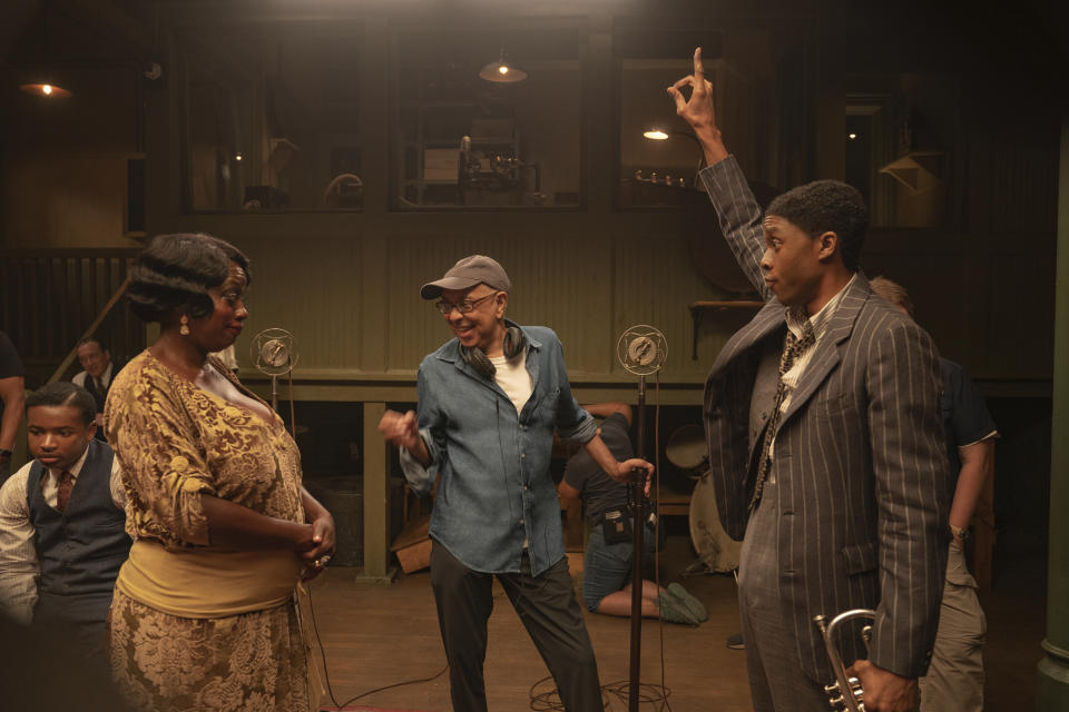 En esta imagen difundida por Netflix, Viola Davis como Ma Rainey, el director George C. Wolfe, en el centro, y Chadwick Boseman como Levee durante la filmación de "Ma Rainey's Black Bottom". (David Lee/Netflix vía AP)