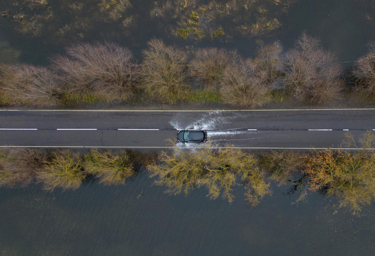 Cars make their way through surface water on the A1101 in Welney in Norfolk, where the River Delph and New Bedford River have flooded the surrounding area. (PA)


