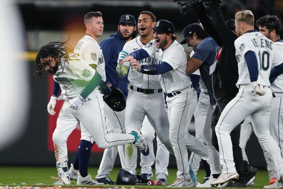 Seattle Mariners' J.P. Crawford, left, is mobbed by teammates, including, from left, Dylan Moore, Andrés Muñoz, Julio Rodríguez and Luis Torrens, as they celebrate his game-winning, two-run double against the Texas Rangers for a 3-2 victory in a baseball game Thursday, Sept. 28, 2023, in Seattle. (AP Photo/Lindsey Wasson)