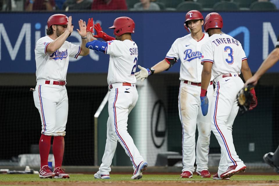 Texas Rangers' Charlie Culberson, Marcus Semien, Corey Seager, right rear, and Leody Taveras (3) celebrate after Semien hit a three-run home run that scored Culberson and Taveras in the fourth inning of a baseball game against the Minnesota Twins, Saturday, July 9, 2022, in Arlington, Texas. (AP Photo/Tony Gutierrez)