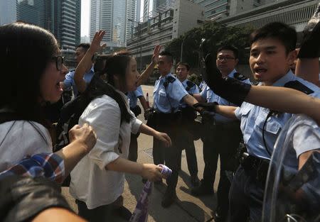 Pro-democracy protesters react as policemen stop them from entering a main road leading to the financial Central district in Hong Kong October 14, 2014. REUTERS/Bobby Yip