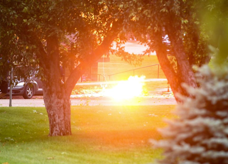 A downed power line electrifies and sets nearby grass and fallen branches on fire after a storm on Tuesday, July 5, 2022, in Sioux Falls.