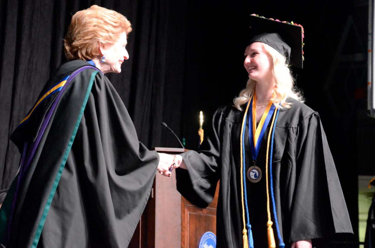 New graduate Hattie Peterman shakes hands with U.S. Sen. Debbie Stabenow as she crosses the stage on May 5, 2023 during the North Central Michigan College commencement ceremony.