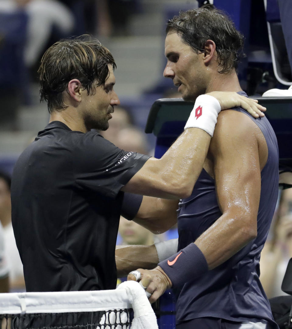 David Ferrer, left, of Spain, talks to Rafael Nadal, also of Spain, after Ferrer retired from their first-round match at the U.S. Open tennis tournament, Monday, Aug. 27, 2018, in New York. (AP Photo/Julio Cortez)