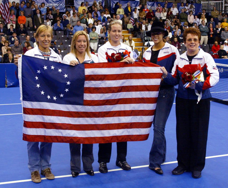 FILE - In this file photo dated Thursday, Oct. 30, 2003, U.S. Fed Cup members from left, Martina Navrartilova, Lisa Raymond, Meghann Shaughnessy, Alexandra Stevenson and Fed Cup Captain Billie Jean King, accept a replica of the Betsy Ross Flag at the Advanta Championships, in VIllanova, USA. The Fed Cup is changing its name to honour tennis great Billie Jean King, becoming The Billie Jean King Cup, the first major global team competition to be named after a woman, it is announced Thursday Sept. 17, 2020.(AP Photo/Miles Kennedy, FILE)