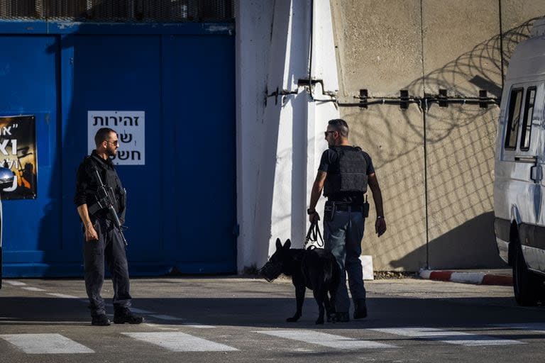 Oficiales de seguridad israelíes custodian la entrada a la prisión de Ofer, mientras llegan prisioneros palestinos desde otra prisión israelí, como parte de un acuerdo entre Israel y el grupo islamista palestino Hamas.