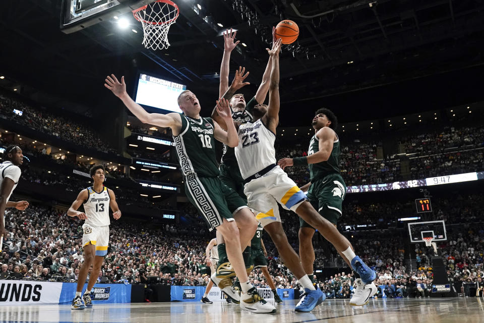 Michigan State center Carson Cooper (15) blocks a Marquette forward David Joplin (23) shot as Joey Hauser (10) defends in the second half of a second-round men's college basketball game in the NCAA Tournament Sunday, March 19, 2023, in Columbus, Ohio. (AP Photo/Paul Sancya)