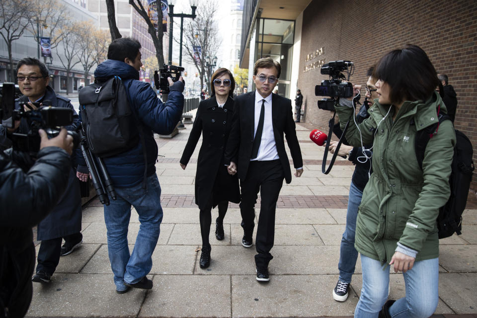 Sun Peng, center right, and Di Ying walk from the federal courthouse in Philadelphia, Monday, Nov. 19, 2018. Their son An-Tso Sun, a Taiwanese exchange student accused of threatening to "shoot up" his high school near Philadelphia has been spared additional time in prison but will be deported. (AP Photo/Matt Rourke)