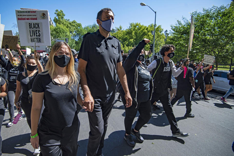 Sacramento Kings' General Manager Vlade Divac, second from left, marches with demonstrators from Golden 1 Center to the state Capitol in Sacramento, Calif., Saturday, June 6, 2020, to protest the killing of George Floyd. The protest is sparked by the death of George Floyd, who died May 25 after he was restrained by Minneapolis police. (Jason Pierce/The Sacramento Bee via AP)