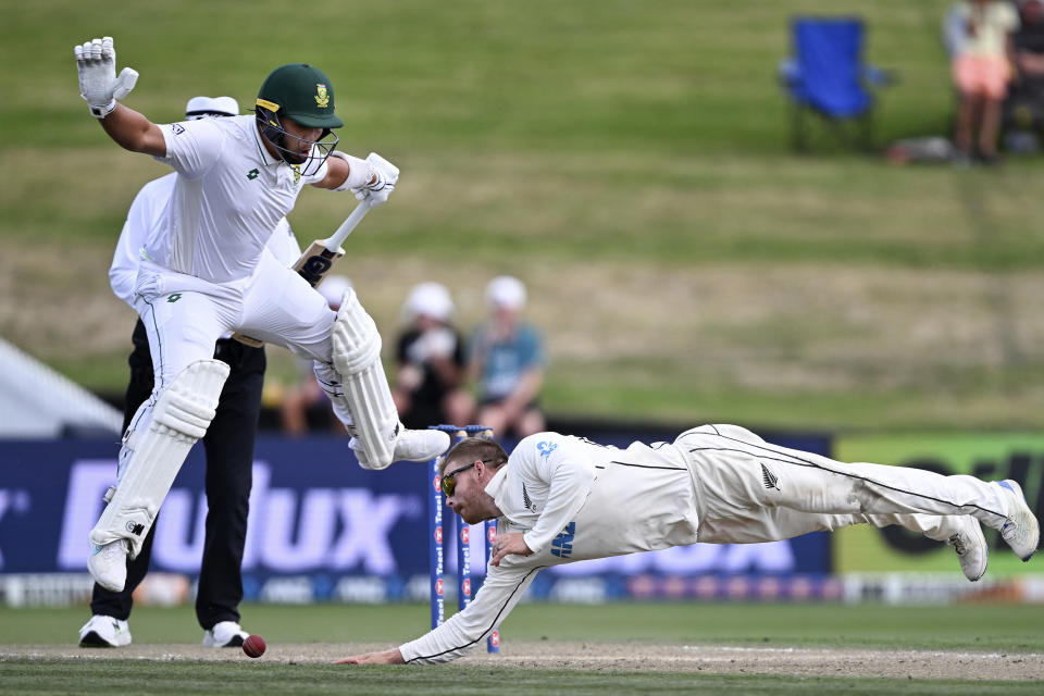 New Zealand bowler Glenn Phillips, right, dives as he attempts to field the ball as South Africa batsman Dane Paterson leaps out of the way on the third day of their cricket test in Hamilton, New Zealand. Thursday, Feb. 15, 2024. (Andrew Cornaga/Photosport via AP)