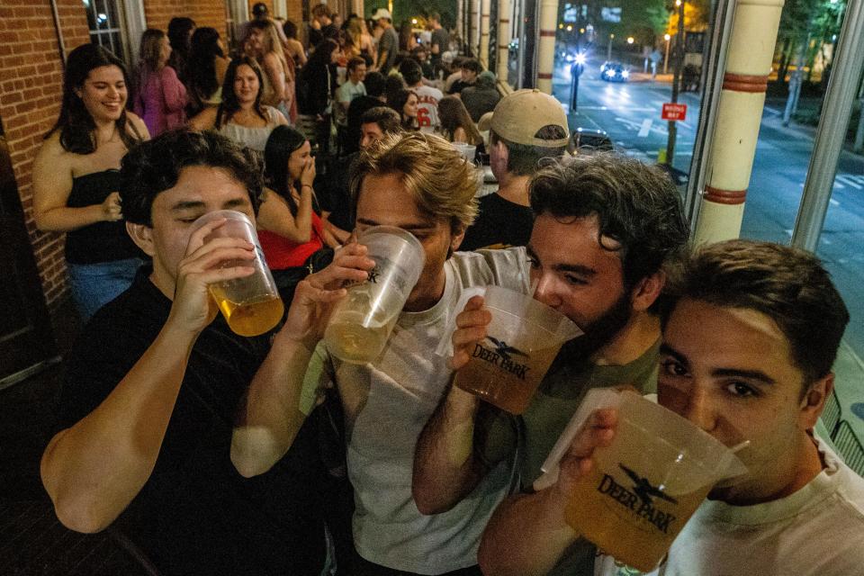 From left, University of Delaware students JT Stroganoff, 22, Jeffrey Roberts, 21, Doug DiDomenico, 22, and Eddie LaRosa, 22, enjoy personal  pitchers on the second floor balcony of the Deer Park Tavern in Newark, Thursday, April 20, 2023.