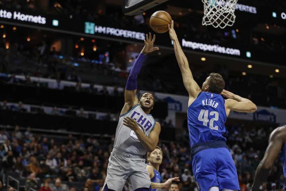 Charlotte Hornets forward Miles Bridges, left, shoots over Dallas Mavericks forward Maxi Kleber during the first half of an NBA basketball game in Charlotte, N.C., Saturday, Feb. 8, 2020. (AP Photo/Nell Redmond)