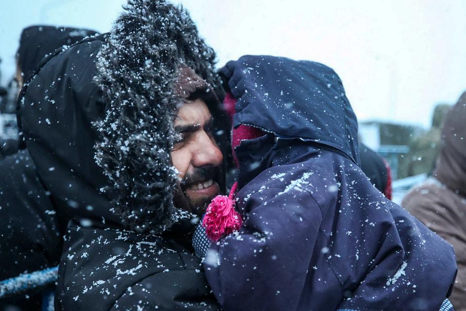 November 23, 2021: A migrant holds his child as he waits to get meal during a snowfall outside a logistics center at the checkpoint "Kuznitsa" at the Belarus-Poland border near Grodno, Belarus. Belarusian authorities say they have helped more than 100 migrants leave the country on Monday and more are prepared to leave Tuesday, a statement that comes after almost two weeks tensions at on the Belarus' border with Poland, where hundreds of migrants remain stuck. 