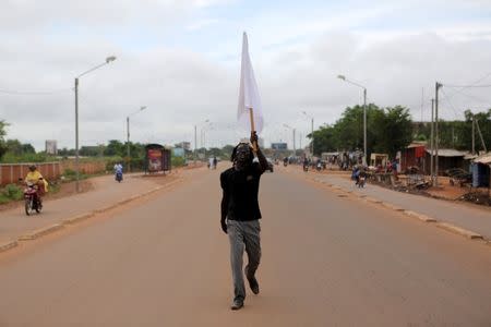 An anti-coup protester carries a white flag down a street in Ouagadougou, Burkina Faso, September 20, 2015. REUTERS/Joe Penney